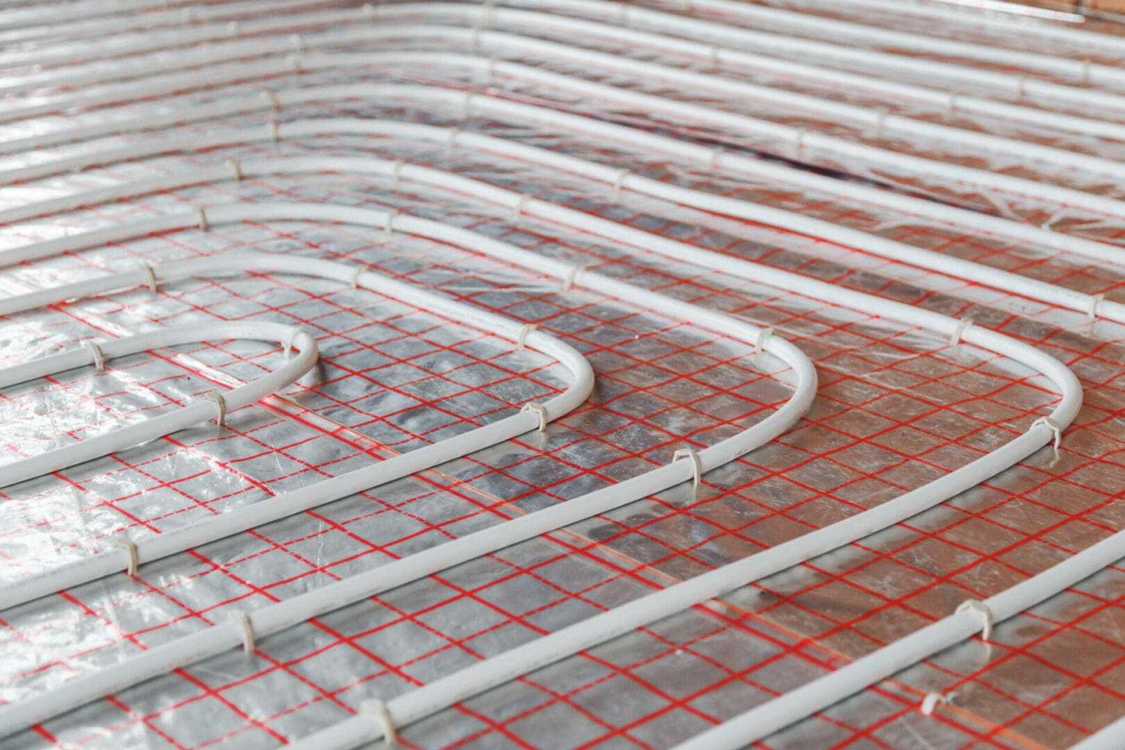 A floor heating system with red pipes and wires.