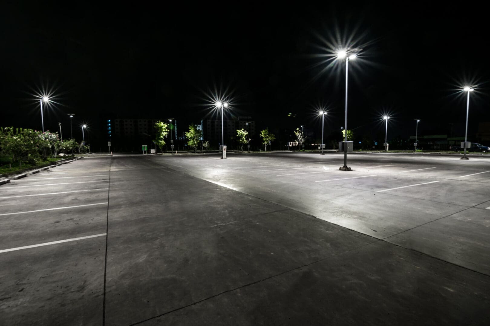 A parking lot with street lights at night.