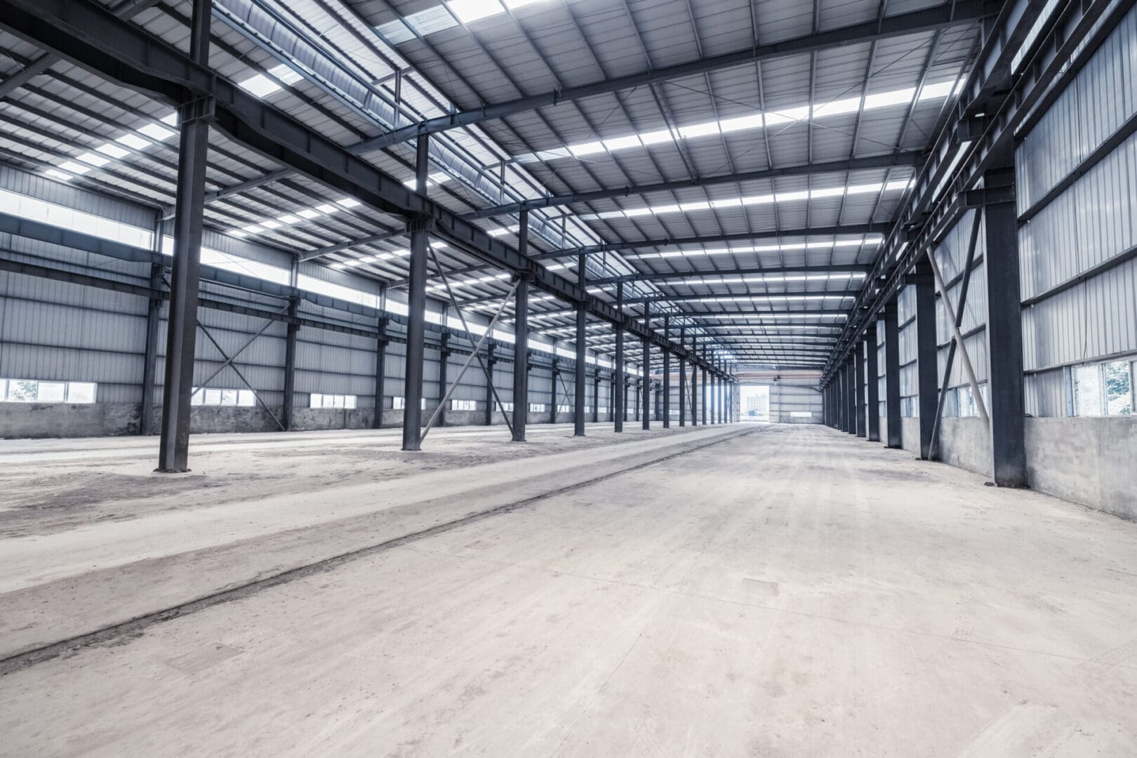 A large warehouse with many windows and lots of steel.