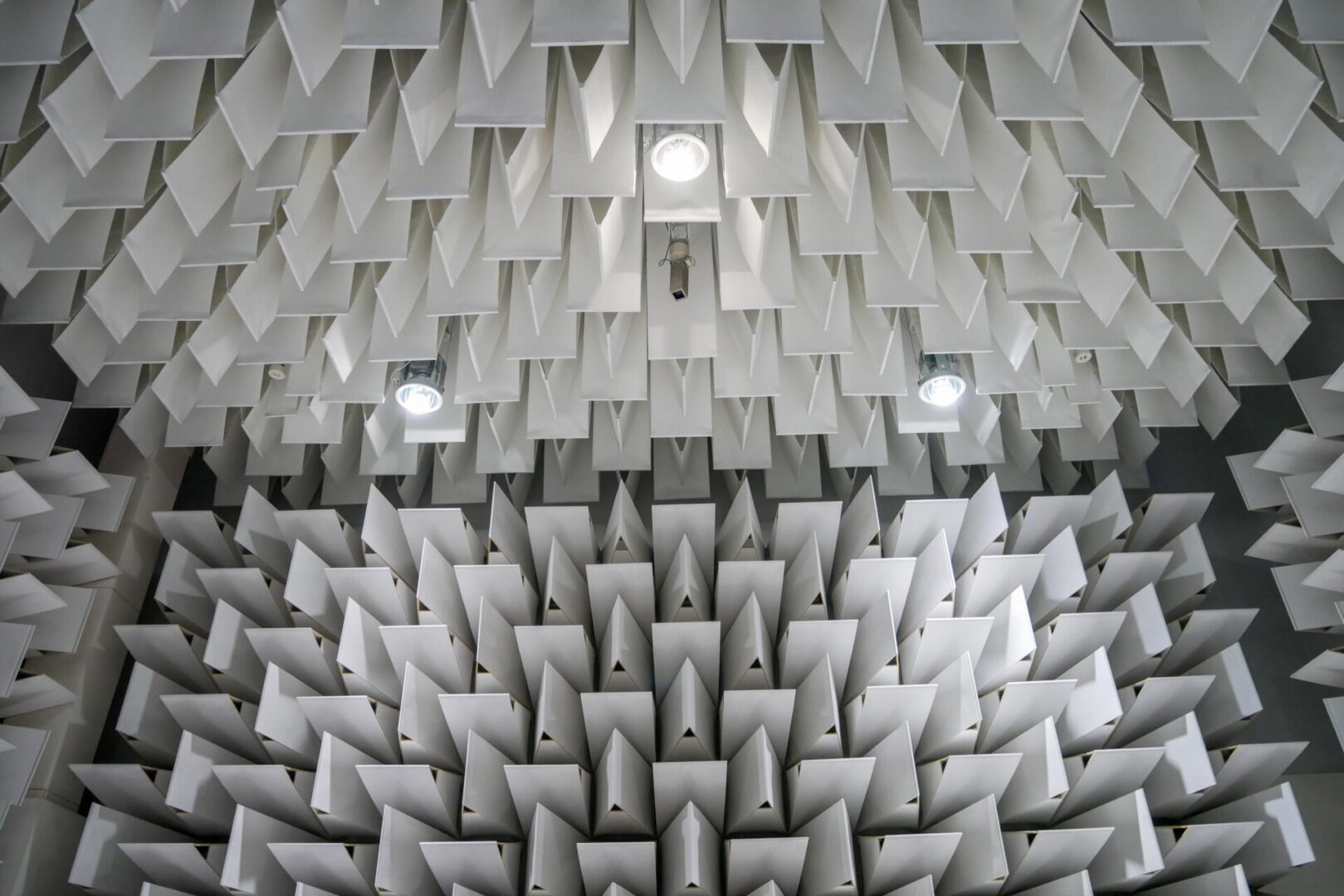 A room with many white cones on the ceiling