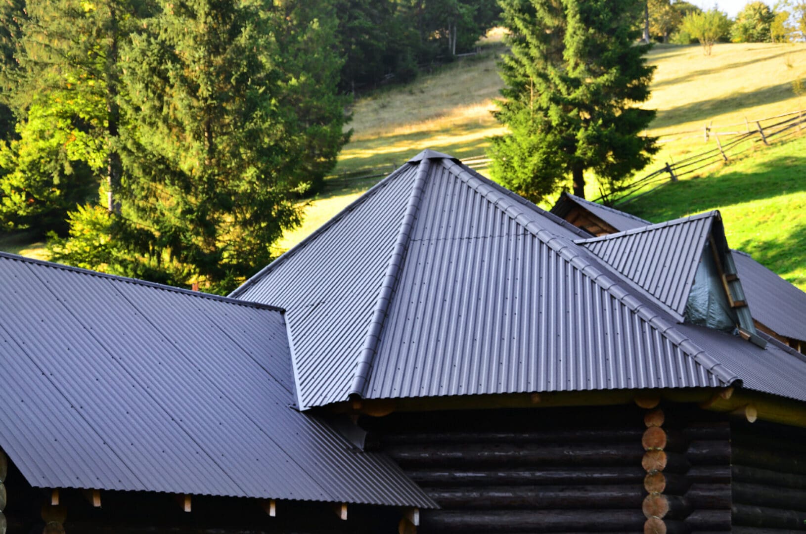 A house with a metal roof and trees in the background.