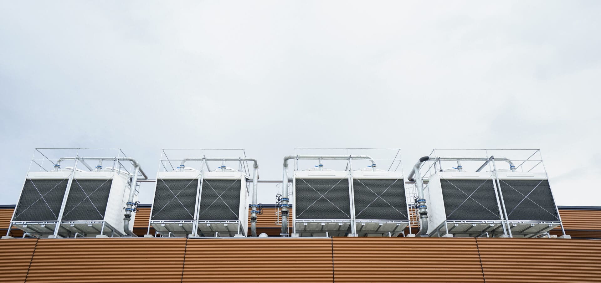 A row of cooling towers on top of a building.