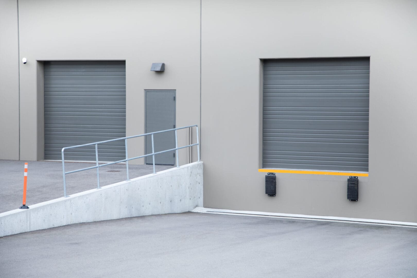 A building with two garage doors and a ramp.