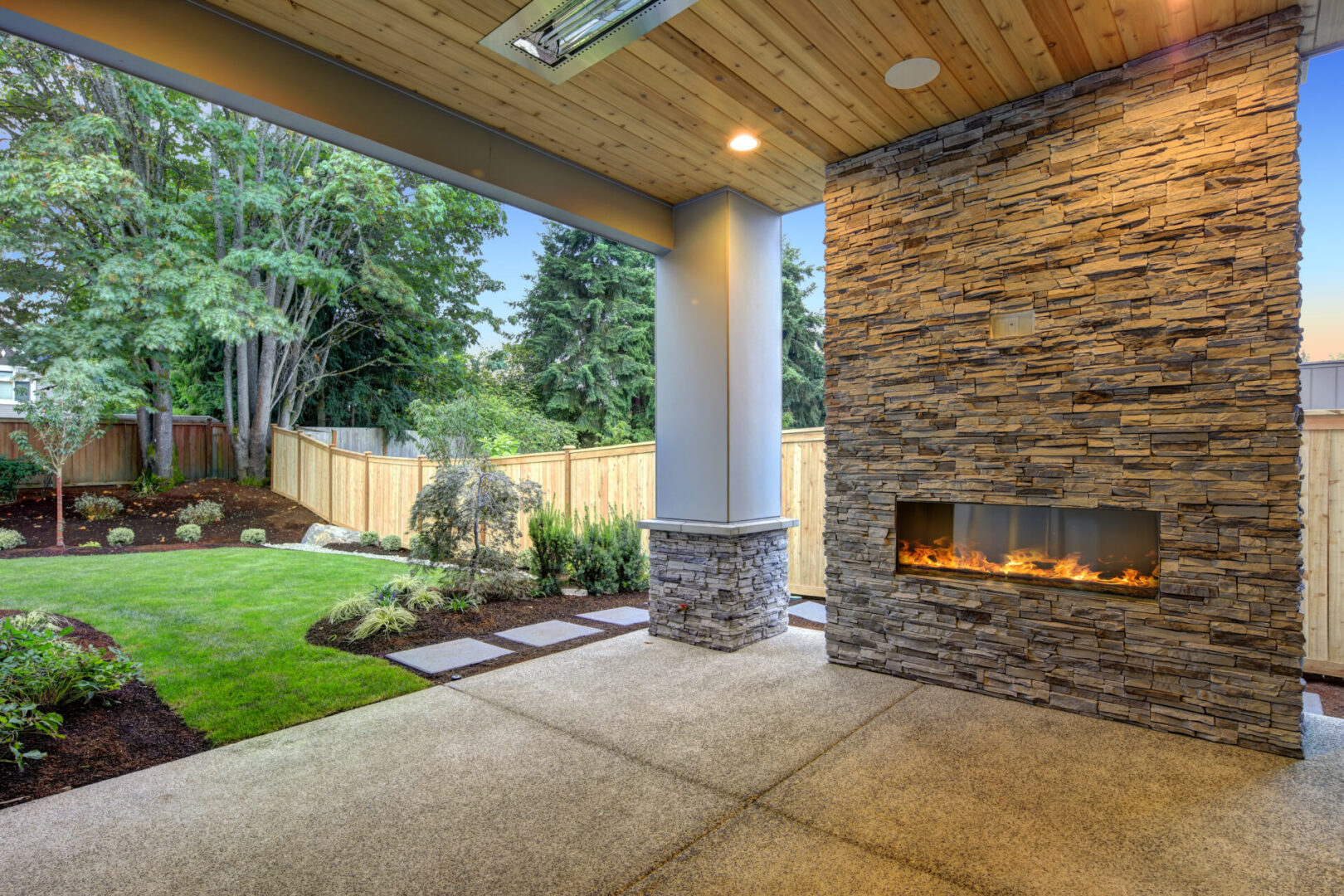 A patio with an outdoor fireplace and covered area.