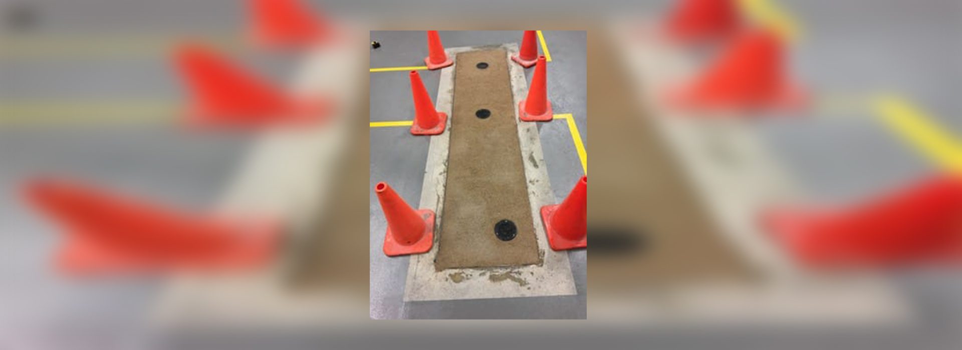 A hole in the ground with orange cones around it.