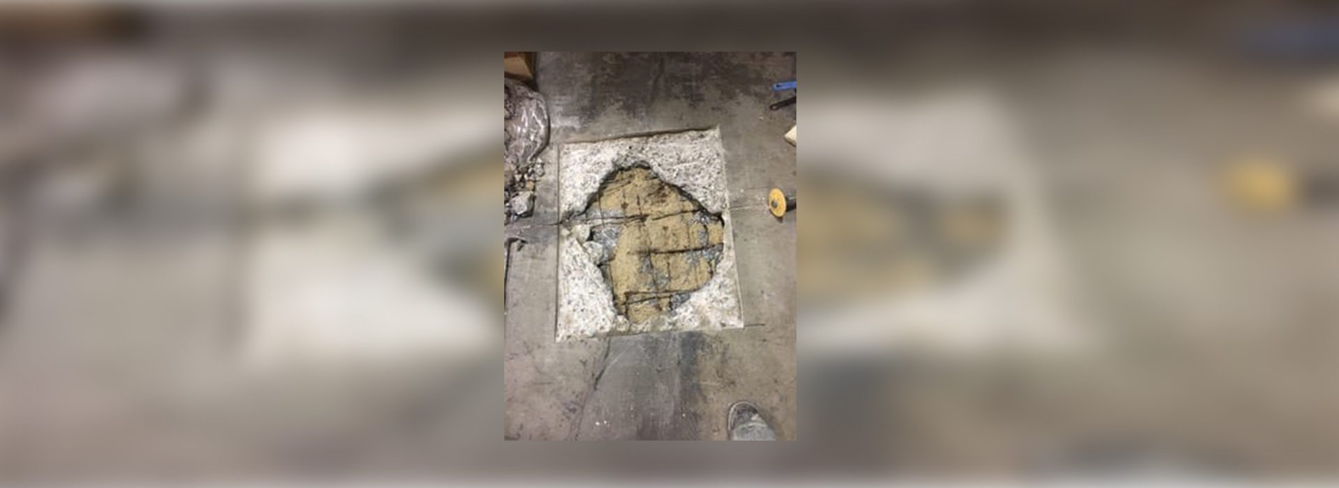 A hole in the floor of an unfinished building.