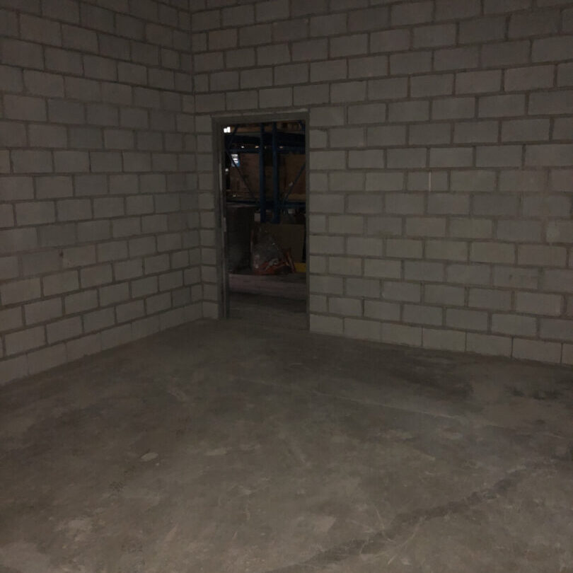 A room with brick walls and concrete floors.