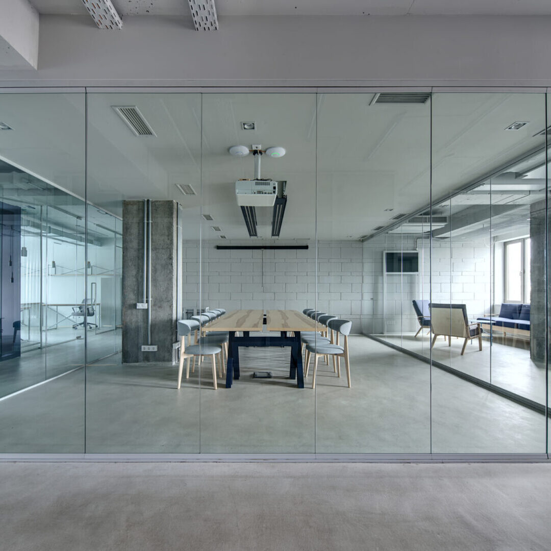 A room with glass walls and a table in the middle.